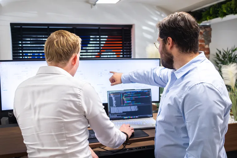 NewHeap engineer werkt aan software achter een bureau
